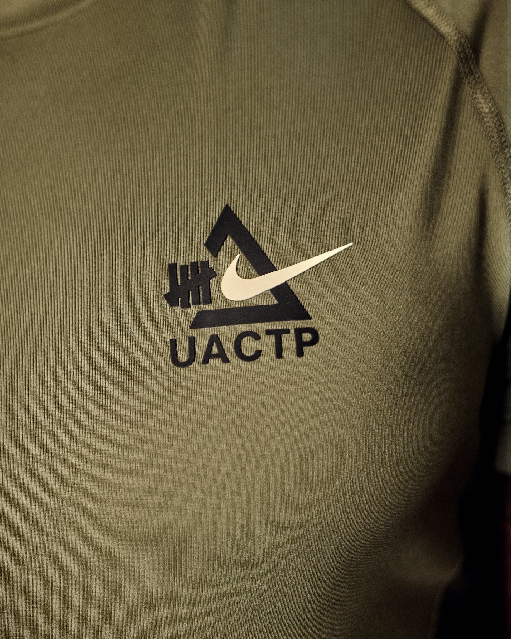 UACTP X NIKE NRG DF SLIM SS TOP - MEDIUM OLIVE